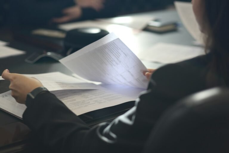 Persona revisa documentos en una mesa, fotografía de archivo