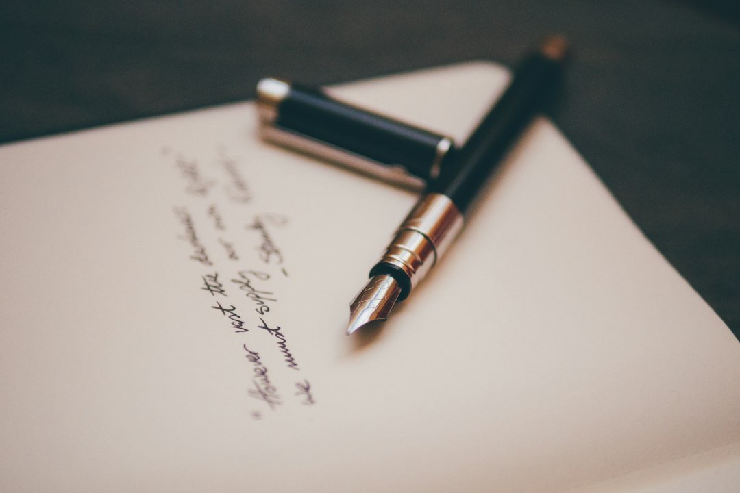 Pluma y documentos sobre una mesa. Fotografía ilustrativa sobre obligaciones de transparencia. Imagen: Álvaro Serrano / Unsplash.