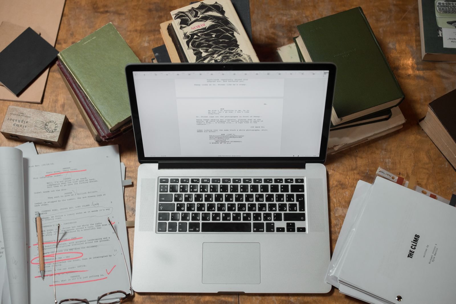 Computadora portátil junto a libros y documentos en una mesa de investigación, ilustración de búsqueda de jurisprudencia.