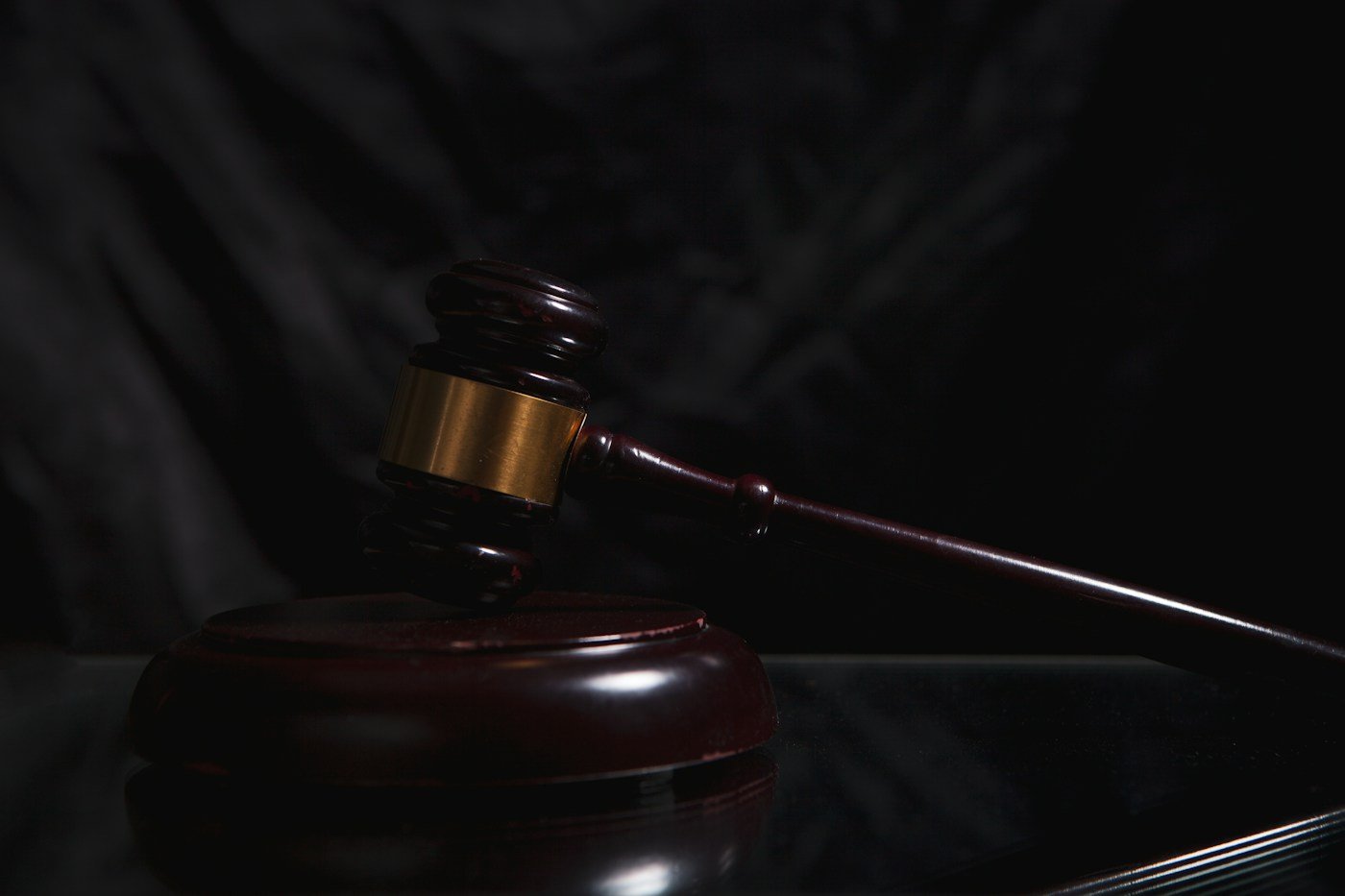 Mazo judicial sobre fondo oscuro, imagen ilustrativa de vigilancia y disciplina judicial